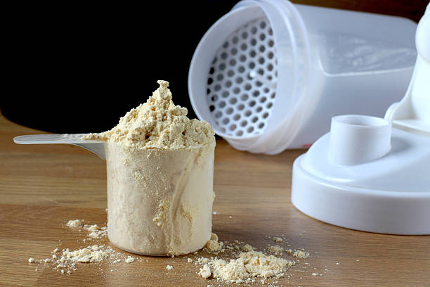 istock Protein powder in measuring cup next to shaker bottle lid 467950052
