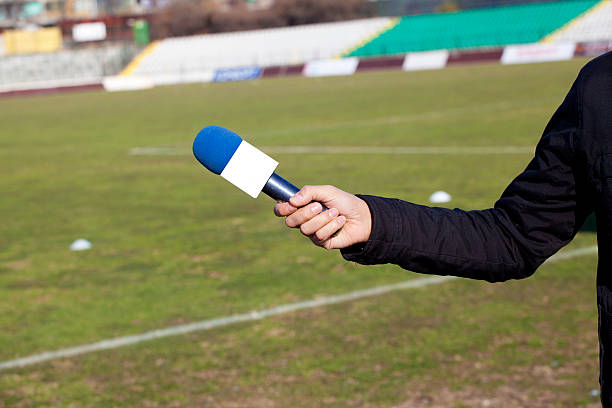 istock hand hold microphone for  interview during a football mach 467954211