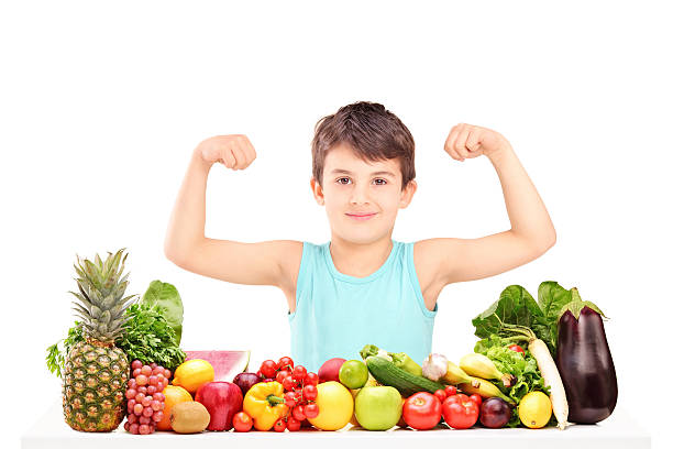 istock Healthy child showing his muscles and sitting on a table 467959123