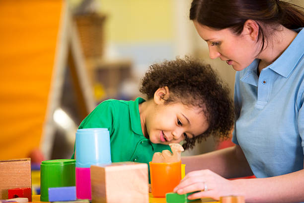 istock Little boy and nursery teacher playing with building blocks 467960236