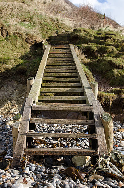 Wooden steps leading down to a pebbled beach stock photo