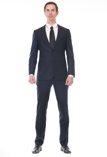 Full body portrait of a businessman in black suit standing on isolated white background