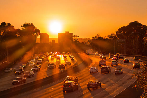 Photograph showing cars in highway traffic on Interstate 5 in warm orange sunset colors in San Diego, California, USA
