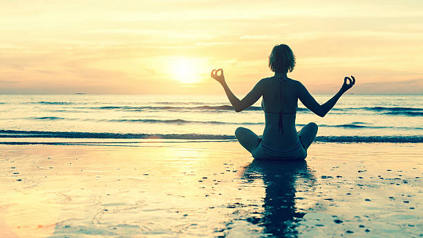 istock Silhouette woman practicing yoga on beach at sunset. 467979456