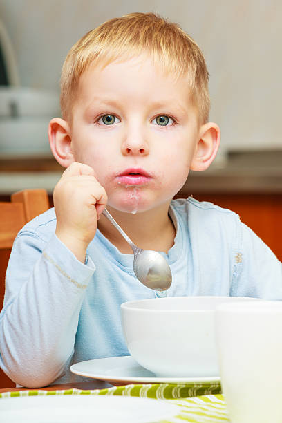 istock Boy kid child eating corn flakes breakfast at the table 467982397