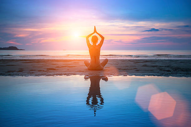 istock Silhouette young woman practicing yoga on beach at surrealistic sunset. 467984760