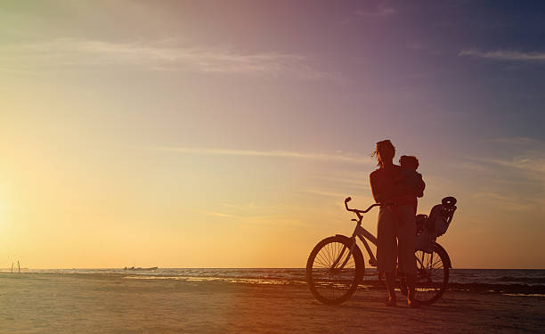 istock mother and baby biking at sunset 467985398