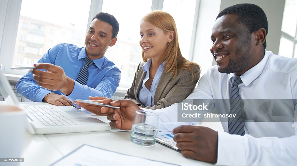 Discussion in office Three business people sharing ideas in office 2015 Stock Photo