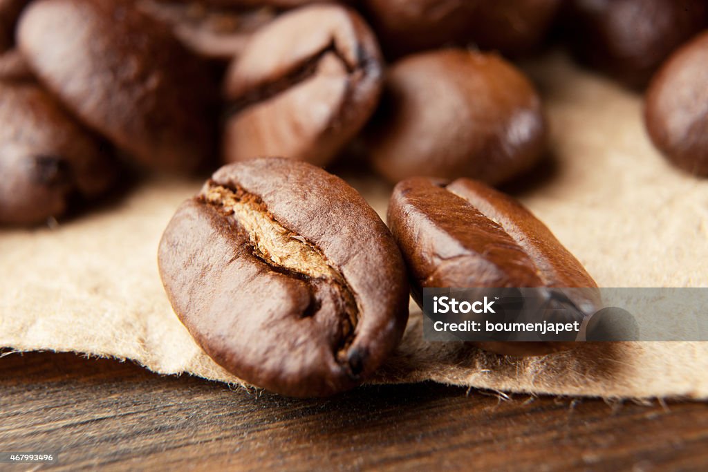 Closeup of coffee beans Closeup of coffee beans on wooden table 2015 Stock Photo