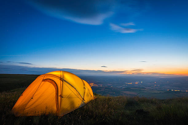 istock Yellow dome tent illuminated on mountain overlooking valley at dusk 468000086