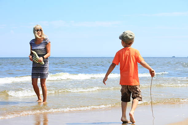 istock happy mother and son playing on beach 468000251