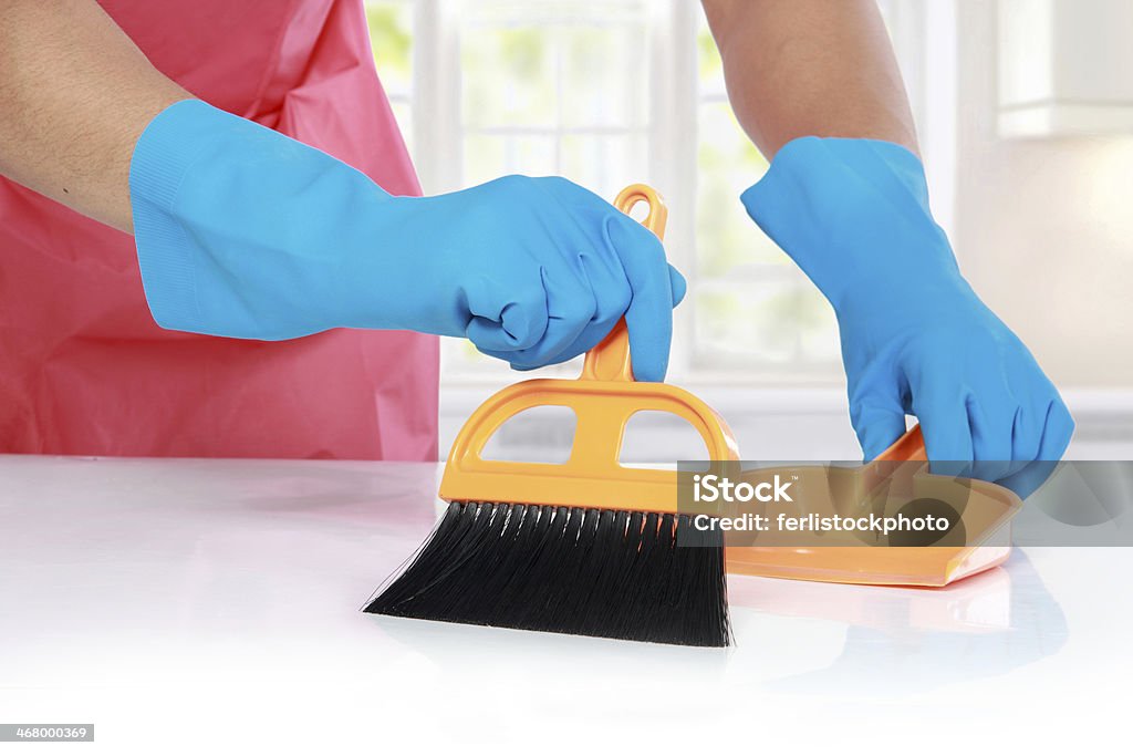 hand with glove using cleaning broom to clean up close up portrait of hand with glove using cleaning broom to clean up the table Dustpan Stock Photo