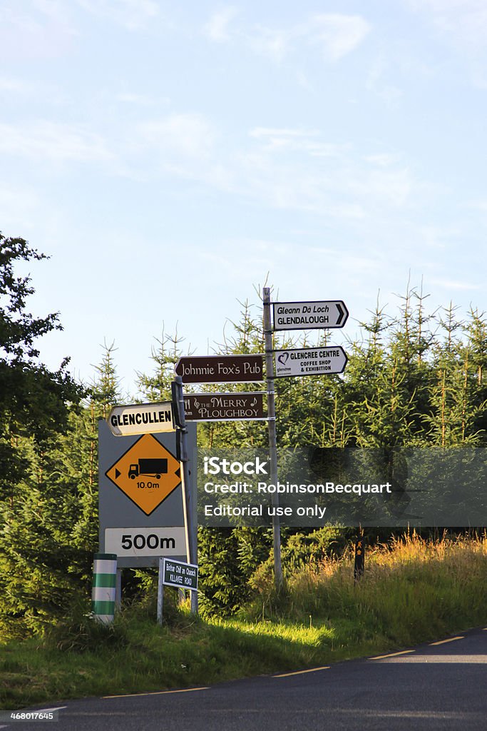 Signpost, Ireland Wicklow, Ireland - August 21, 2012 : A signpost beside a wood forest is indicating the direction for Glendalough and other famous places in Ireland. Arrow Symbol Stock Photo