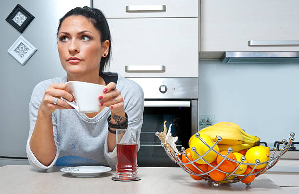 istock attractive woman drinking coffee in the kitchen 468020147