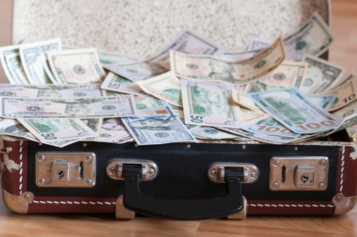 Suitcase full of U.S. Dollar as background.