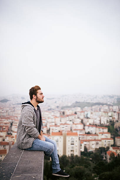 istock Young man sitting with cityscape 468039574