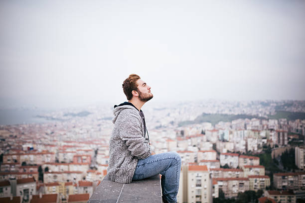 istock Young man sitting with cityscape 468039576