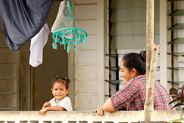 femme avec enfants assis sur un porche de maison - vavau islands photos et images de collection