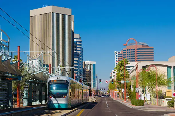 Midtown Phoenix business district with a light rail line and train in the foreground.