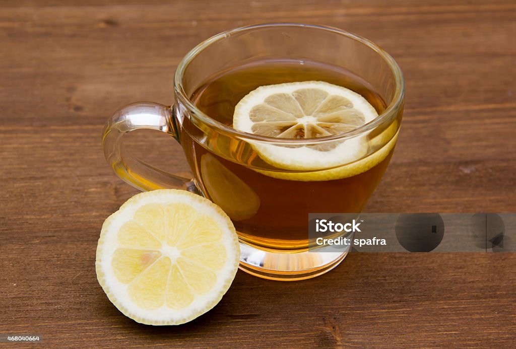 Tea with lemon on wood Tea with lemon on cup on wooden table 2015 Stock Photo