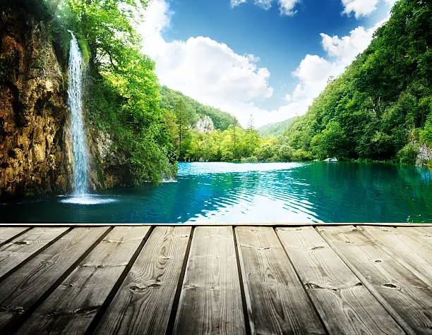 Photo of waterfall in deep forest of croatia and wood pier