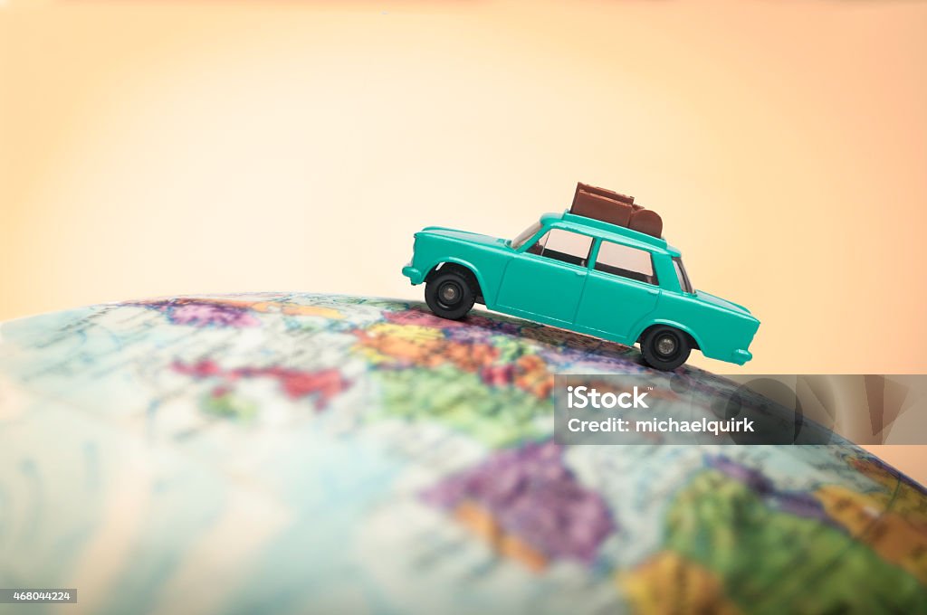 Vacationing toy car on a globe Close-up of a toy car with luggage on holiday sitting on a globe Car Stock Photo