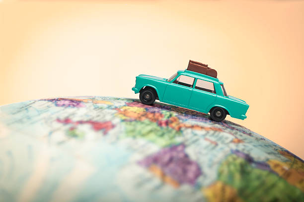 Vacationing toy car on a globe stock photo