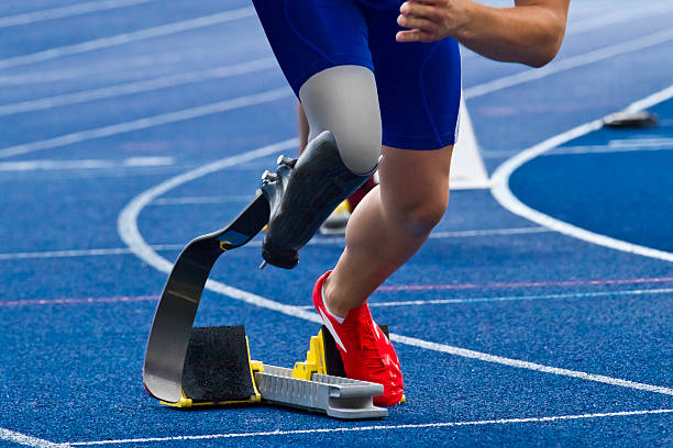 Handicapped sprinter on blue track athlete with handicap starts the race athlete with disabilities photos stock pictures, royalty-free photos & images