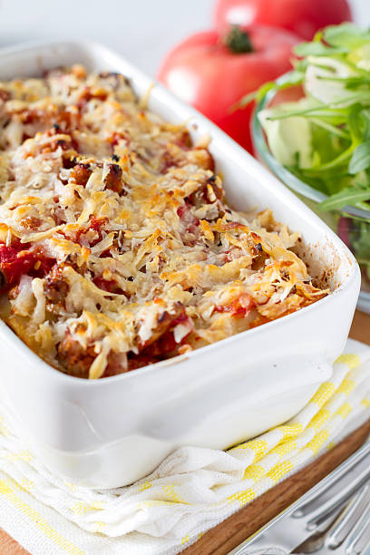 istock Lasagna in white form, salad in glass bowl, tomato 468045624