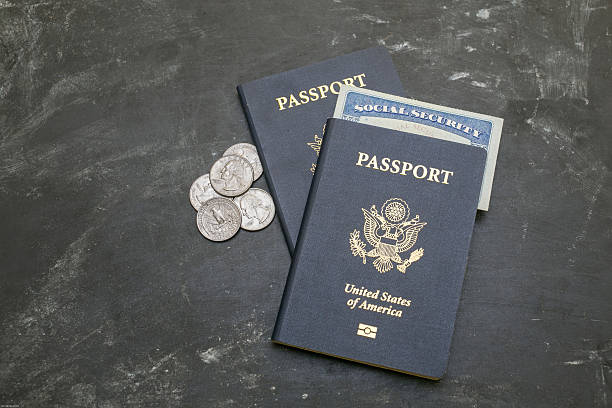 Two American passports and social security card on black background Two US passports on black background. American citizenship. Social security card in a document. Traveling around the world. Coins on a side social security social security card identity us currency stock pictures, royalty-free photos & images