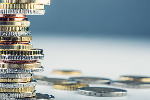 istock A stack and a scatter of Euro coins on a white desk 468046162