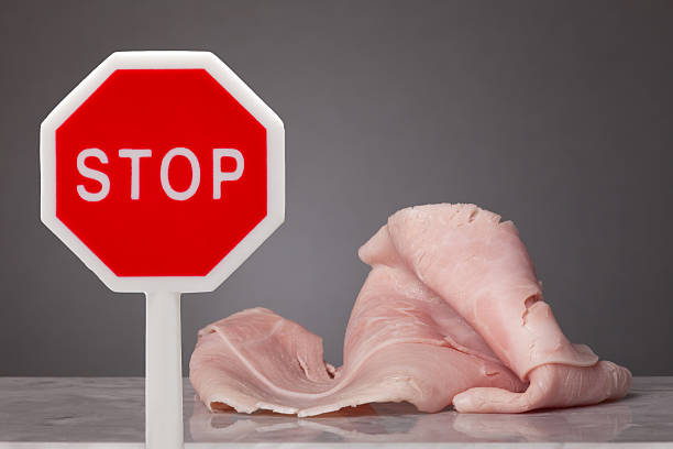 Do not eat meat A piece of boiled ham laying on a marble plate. In front a stop sign dont eat meat stock pictures, royalty-free photos & images