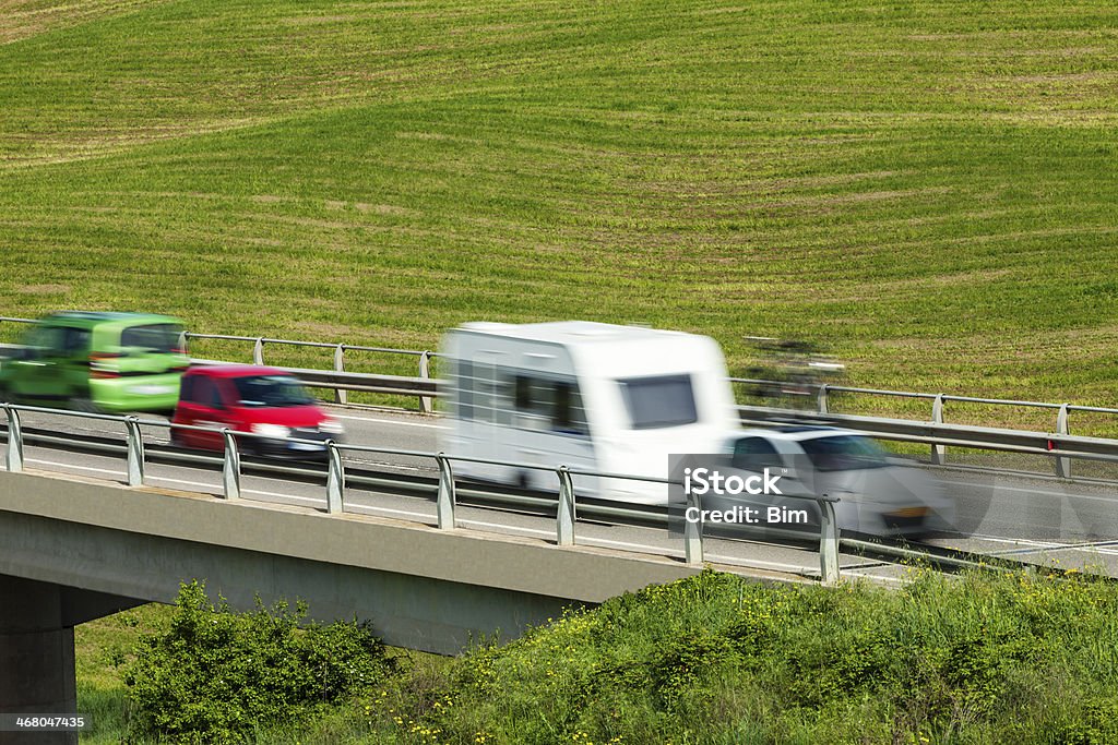 Coches en la carretera elevada acelere Over Green Hills - Foto de stock de Aire libre libre de derechos