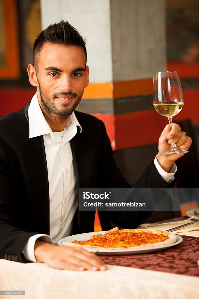 Handsome Man eating pizza in restaurant Young Man eating pizza in restaurant 2015 Stock Photo