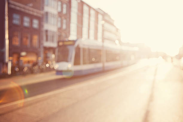 City commuters. High key blurred image of people riding a bike in the street. Unrecognizable faces.