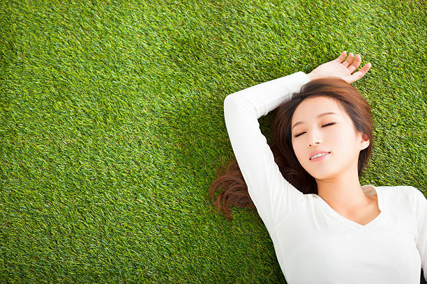 istock Relaxed young woman  lying on the grass 468051492