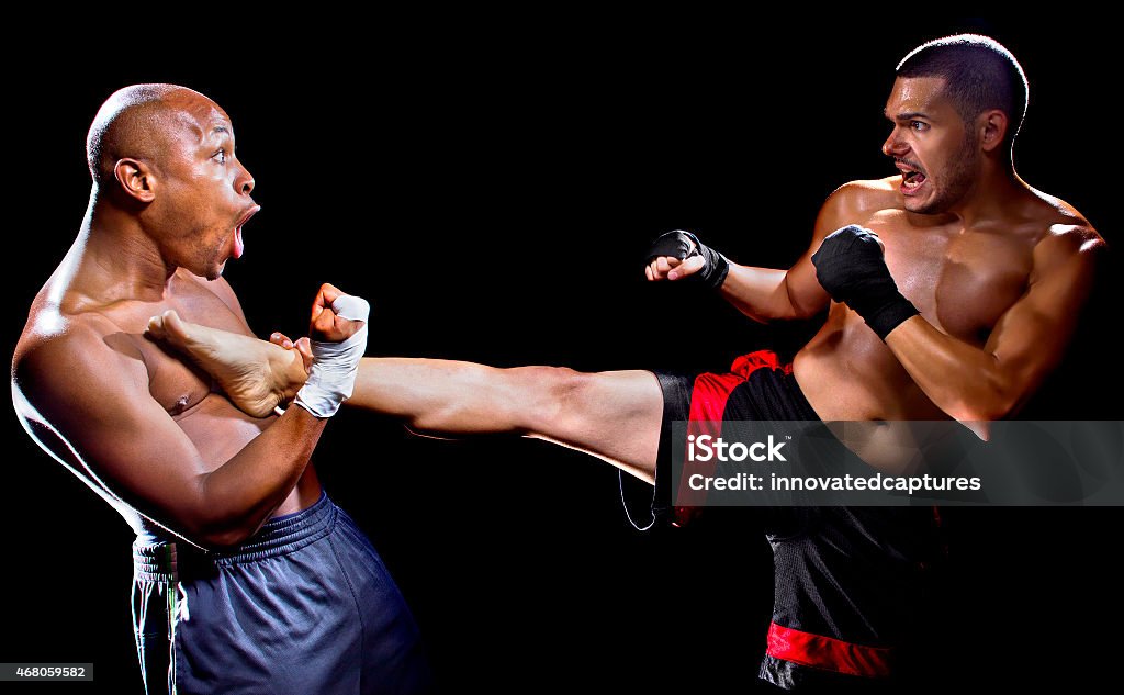 Male MMA Fighter Countering or Blocking a Kick mma fighter performing a counter attack from a kick Mixed Martial Arts Stock Photo