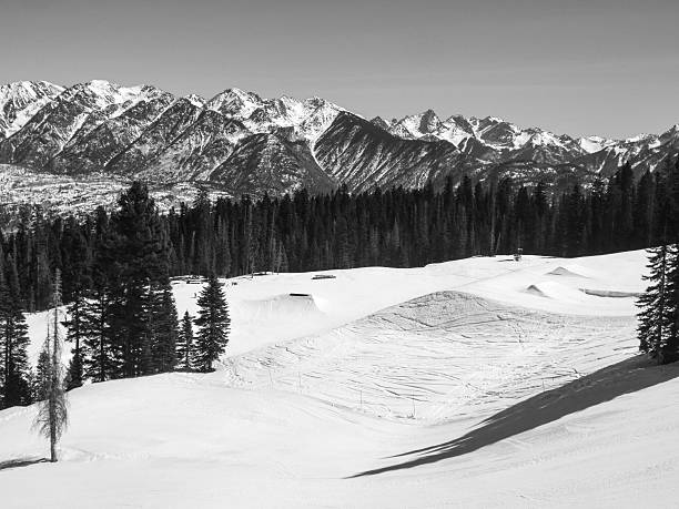 Monochromatic terrain park jumps at a scenic ski resort