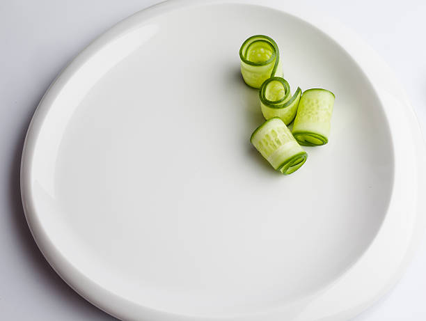 Rolled cucumber slices on white plate
