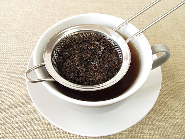 Black tea in tea strainer stock photo