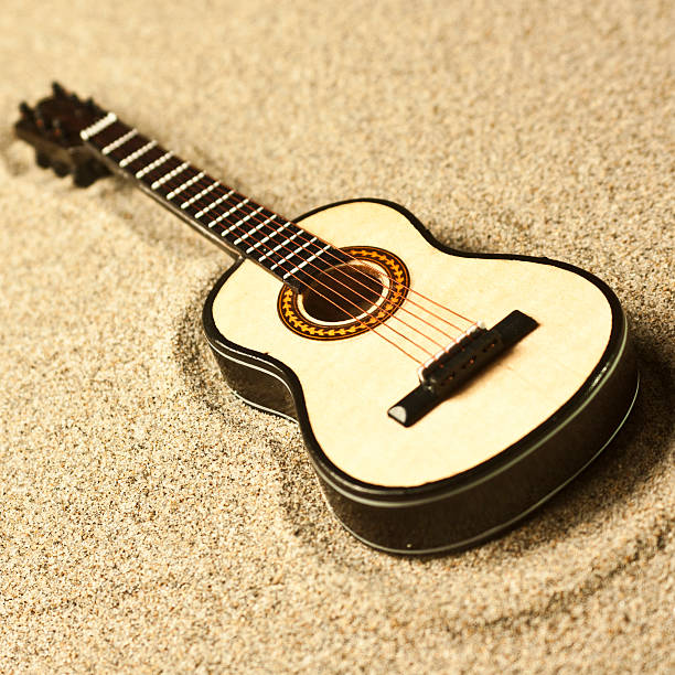 istock spanish guitar in the sand 468074472