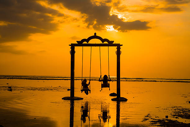 Gili Gate Beautifull Gate with girls swing above ocean sunset. View from Gili island, Trawangan,  gili trawangan stock pictures, royalty-free photos & images