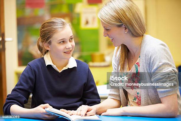 Lehrer Lesen Mit Weiblichen Schüler Am Schalter Im Klassenzimmer Stockfoto und mehr Bilder von Lehrkraft