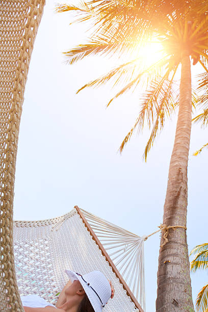 istock Young woman with white hat is relaxing in a hammock. 468084393