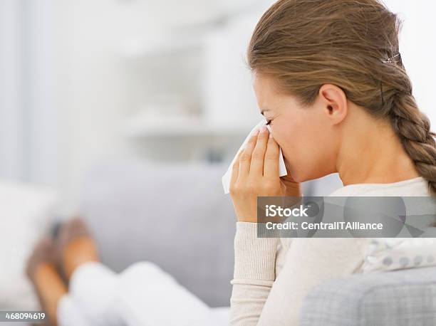 Young Woman Laying On Sofa And Blowing Nose Stock Photo - Download Image Now - Adult, Allergy, Beautiful People