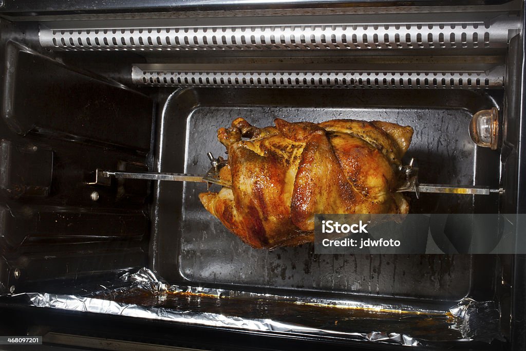 Rotisserie Chicken A chicken cooking on a horizontal rotisserie. Bird Stock Photo