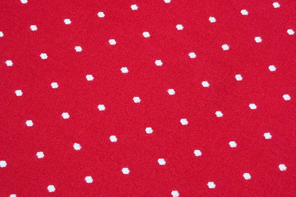 white dots embroidered on bright red textile