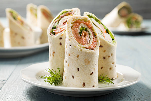 Mix of wraps with ham, chicken, salmon and crab served Mix of wraps with ham, chicken, salmon and crab served on a plate wrap sandwich photos stock pictures, royalty-free photos & images