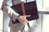 Businessman holding briefcase, close up