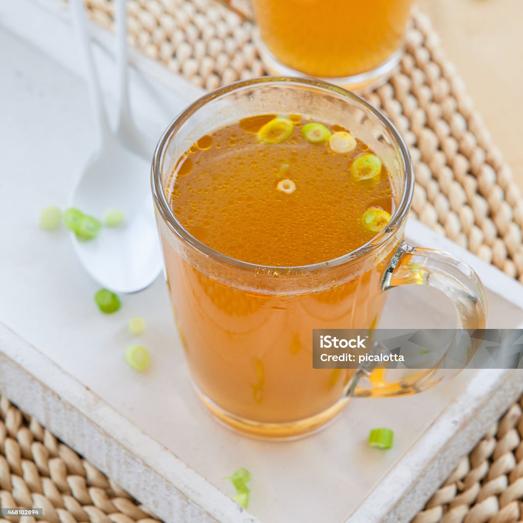 Homemade bone broth Homemade bone broth with leek in glass cup Broth Stock Photo